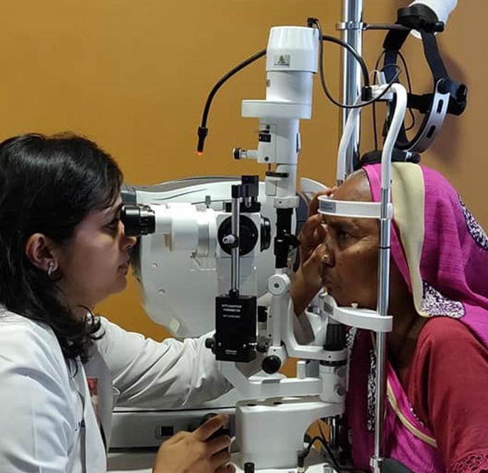 the lady doctor is checking of old women eye by machine